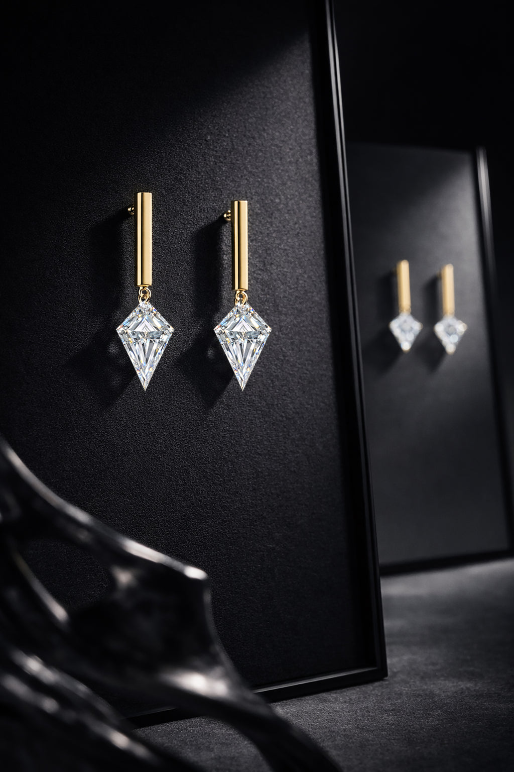 Two single kite-cut floating diamond drop studs displayed together on a black jewelry stand