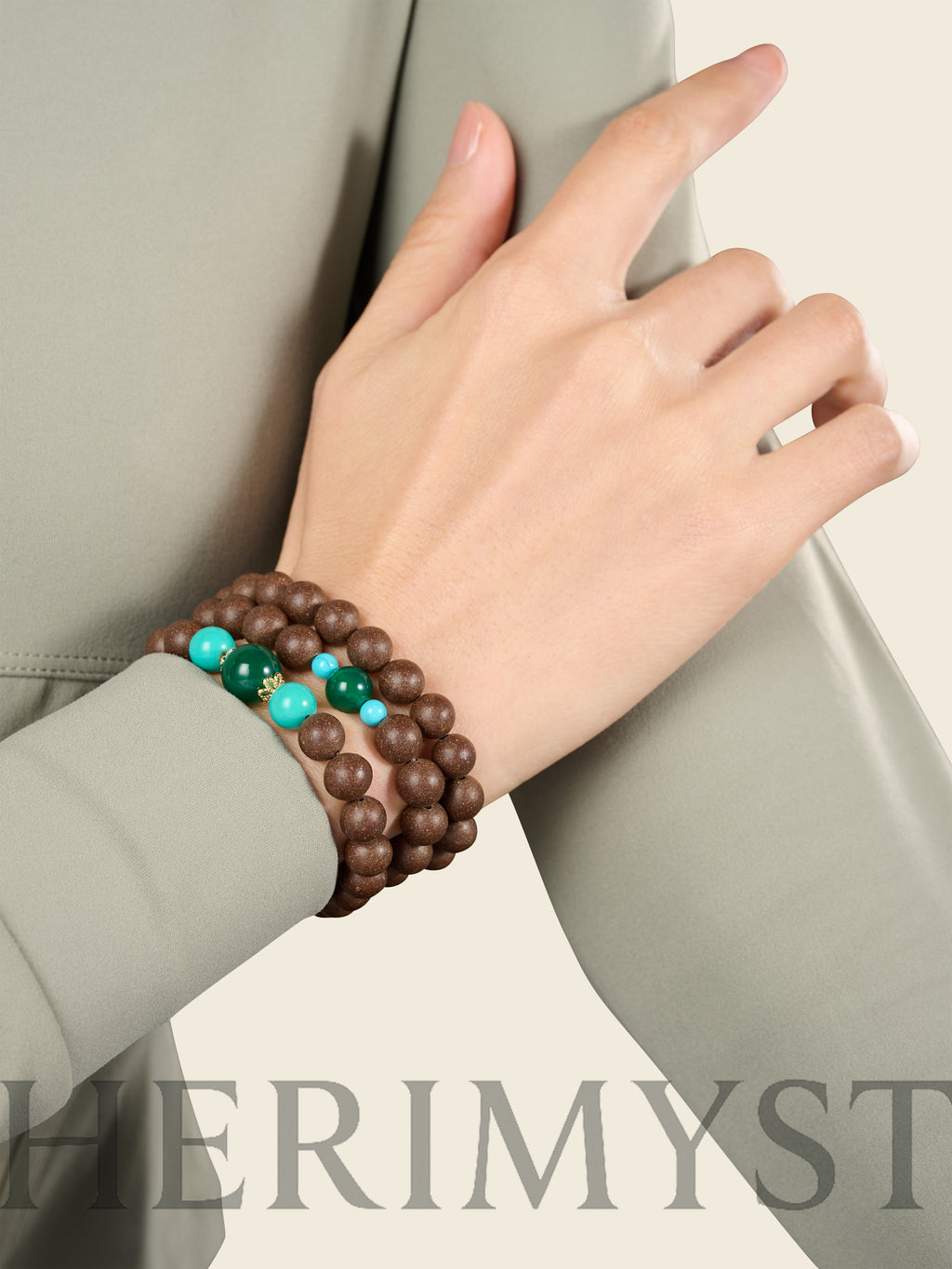 Close-up of agarwood incense bead bracelets on wrist, featuring green jade-toned beads and turquoise accents in a calm, modern styling.
