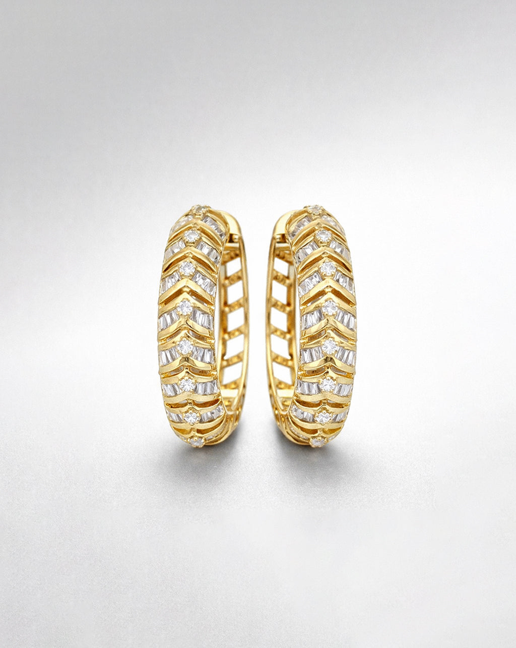 14K yellow gold diamond hoop earrings with alternating baguette and round diamonds, half-set design with openwork back, shown with generous white space on a light grey background