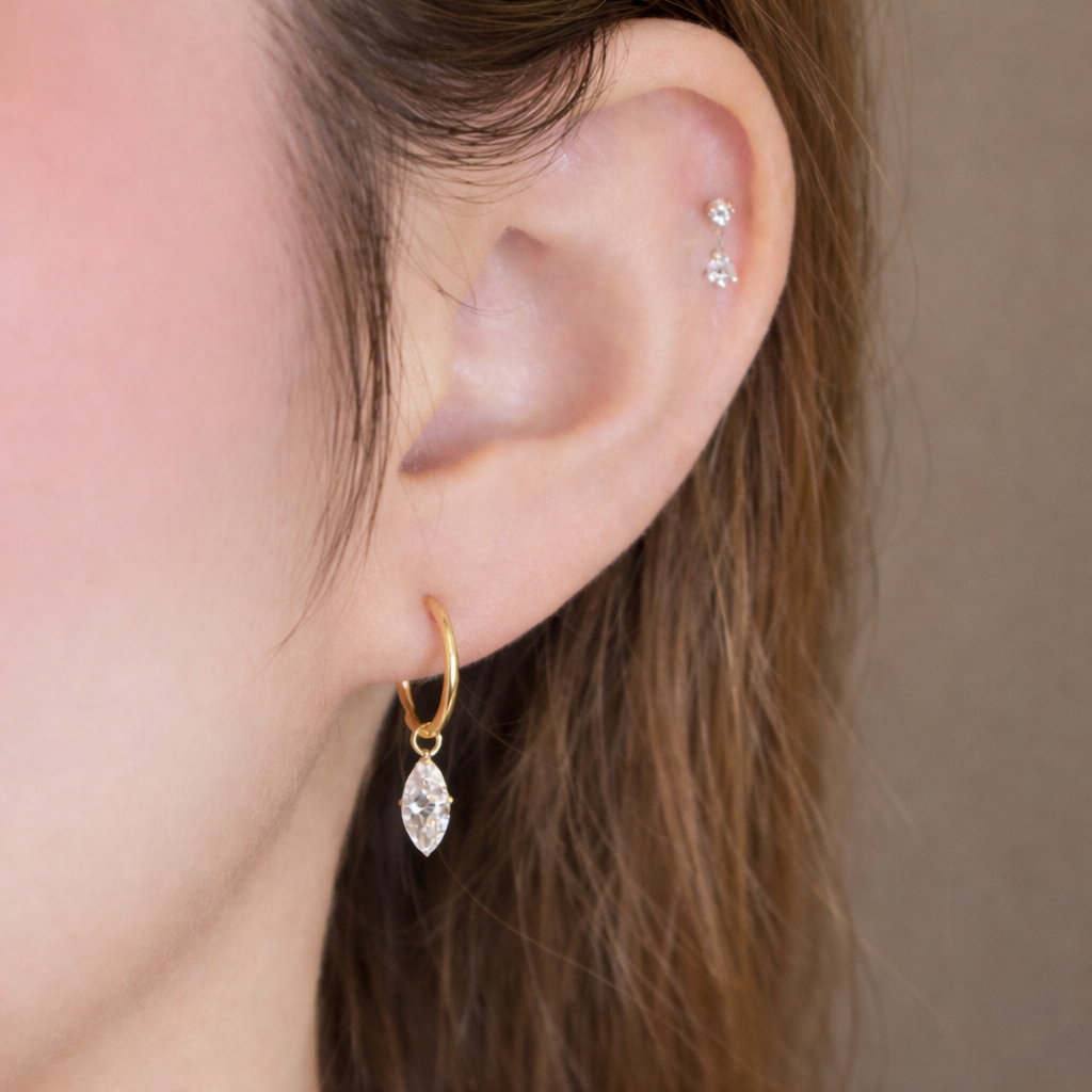 Lab grown floating diamond earring in 14K yellow gold, marquise-cut diamond worn on the ear.