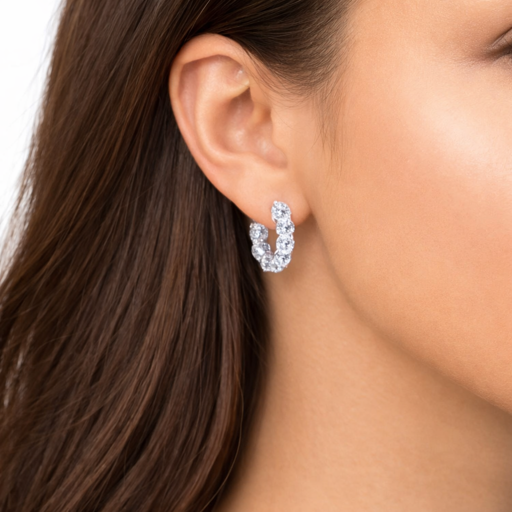 Model wearing 7ct lab-grown diamond huggie hoop earrings in 14K white gold, hair tucked behind the ear