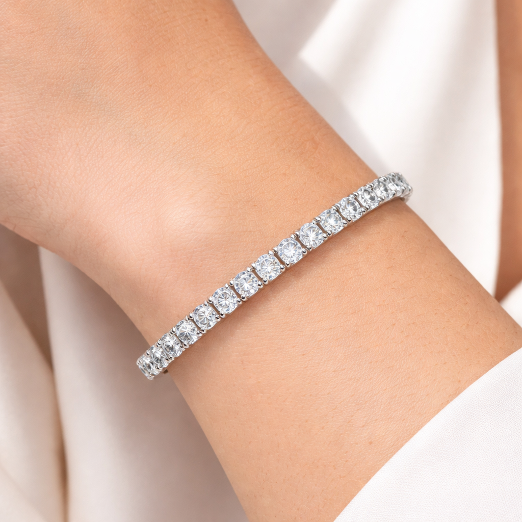 Round brilliant diamond tennis bracelet worn on wrist, set in 14K white gold