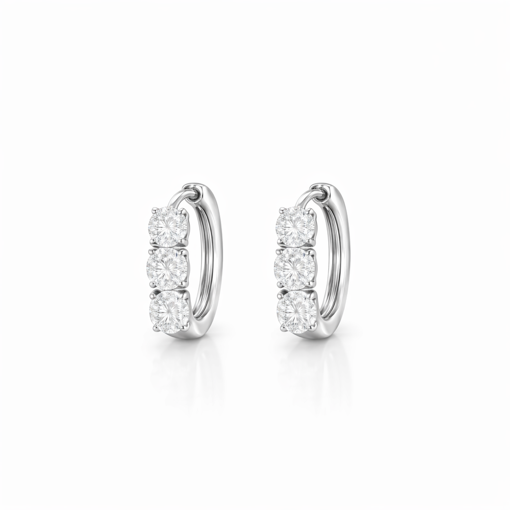 Three-stone lab-grown diamond huggie earrings worn on ear, 14K white gold, subtle everyday sparkle