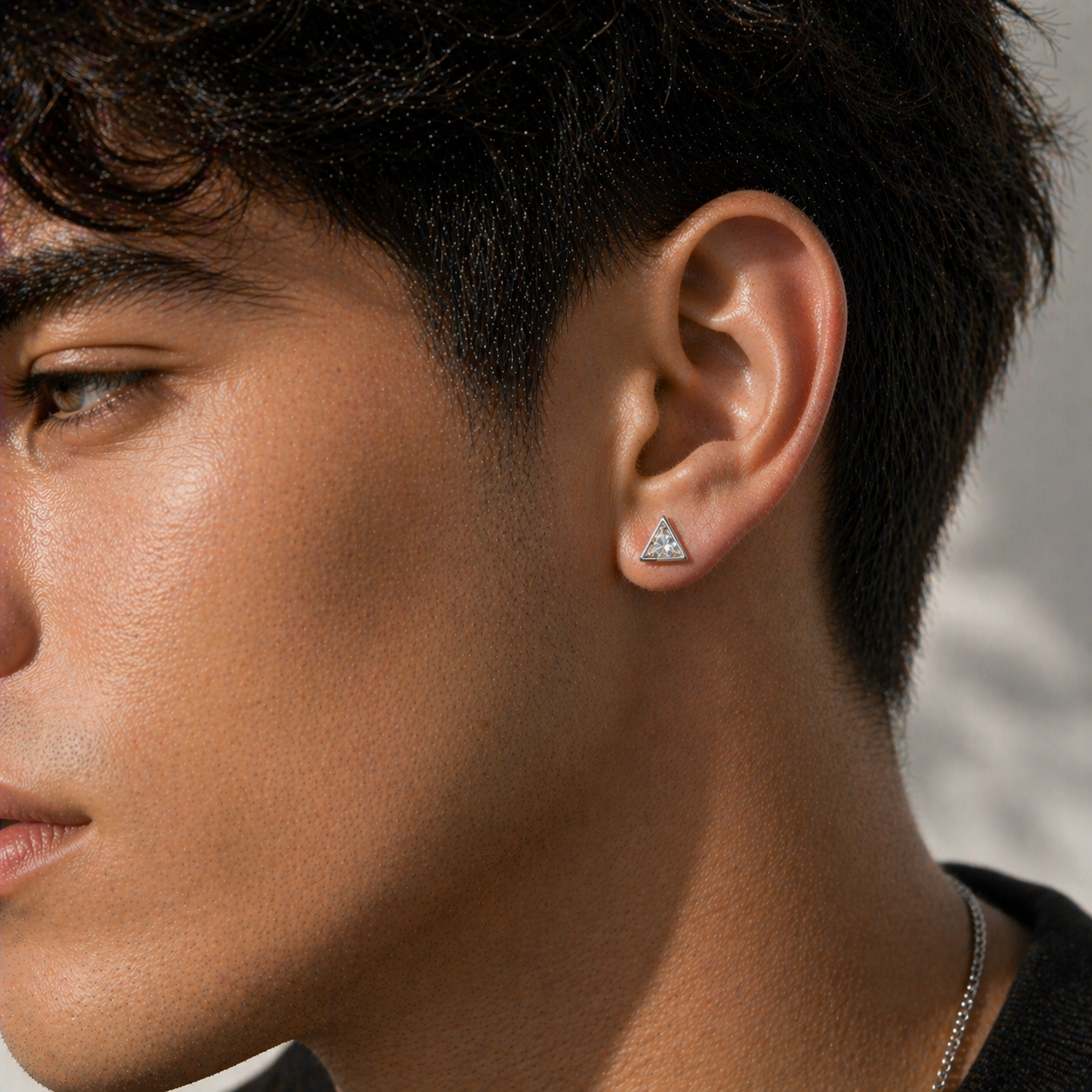 man wearing 1 carat triangle diamond stud earring in white gold, minimalist mens jewelry close-up