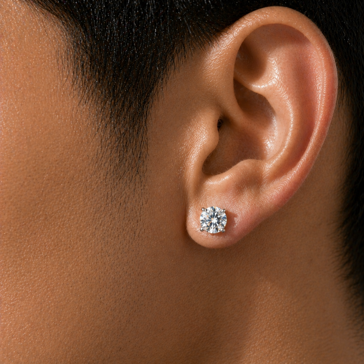 Close-up of a 1 carat round brilliant diamond stud earring for men in 14K white gold with centered brilliance