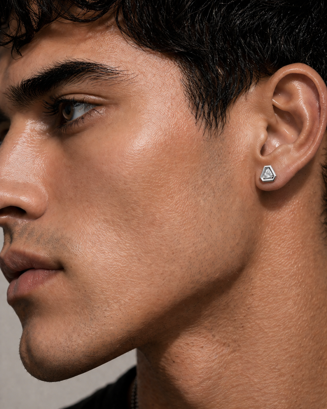 triangular diamond stud earring for men in 14k white gold, geometric setting with clean edge reflections, close-up ear view