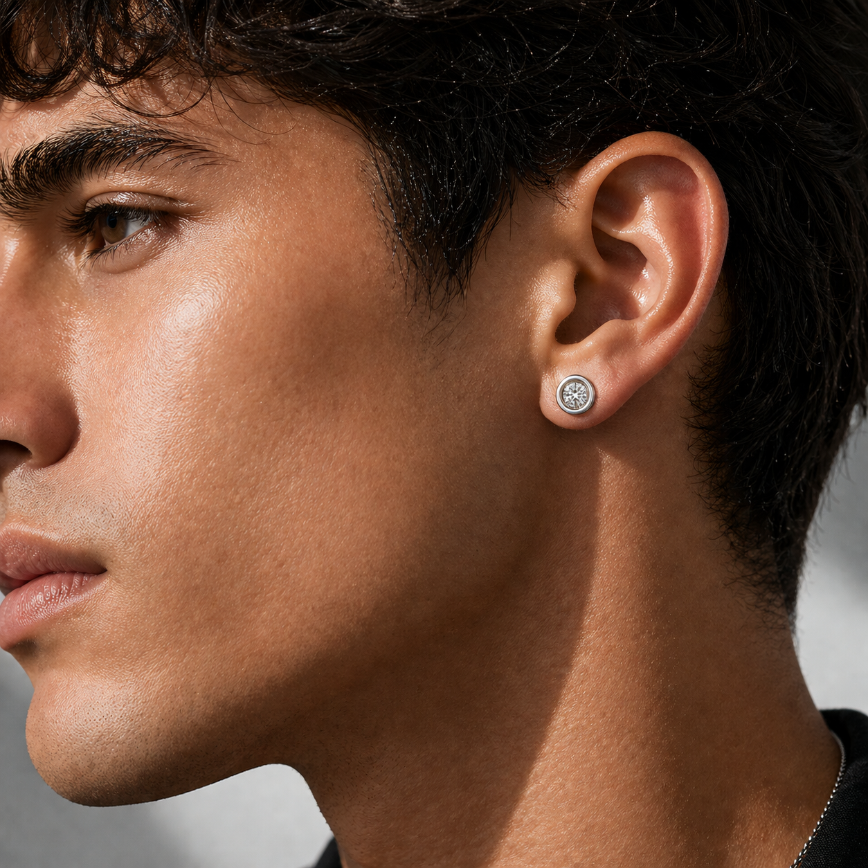 Recessed diamond stud earring on ear, 14K white gold bezel setting with embedded stone and central brilliance