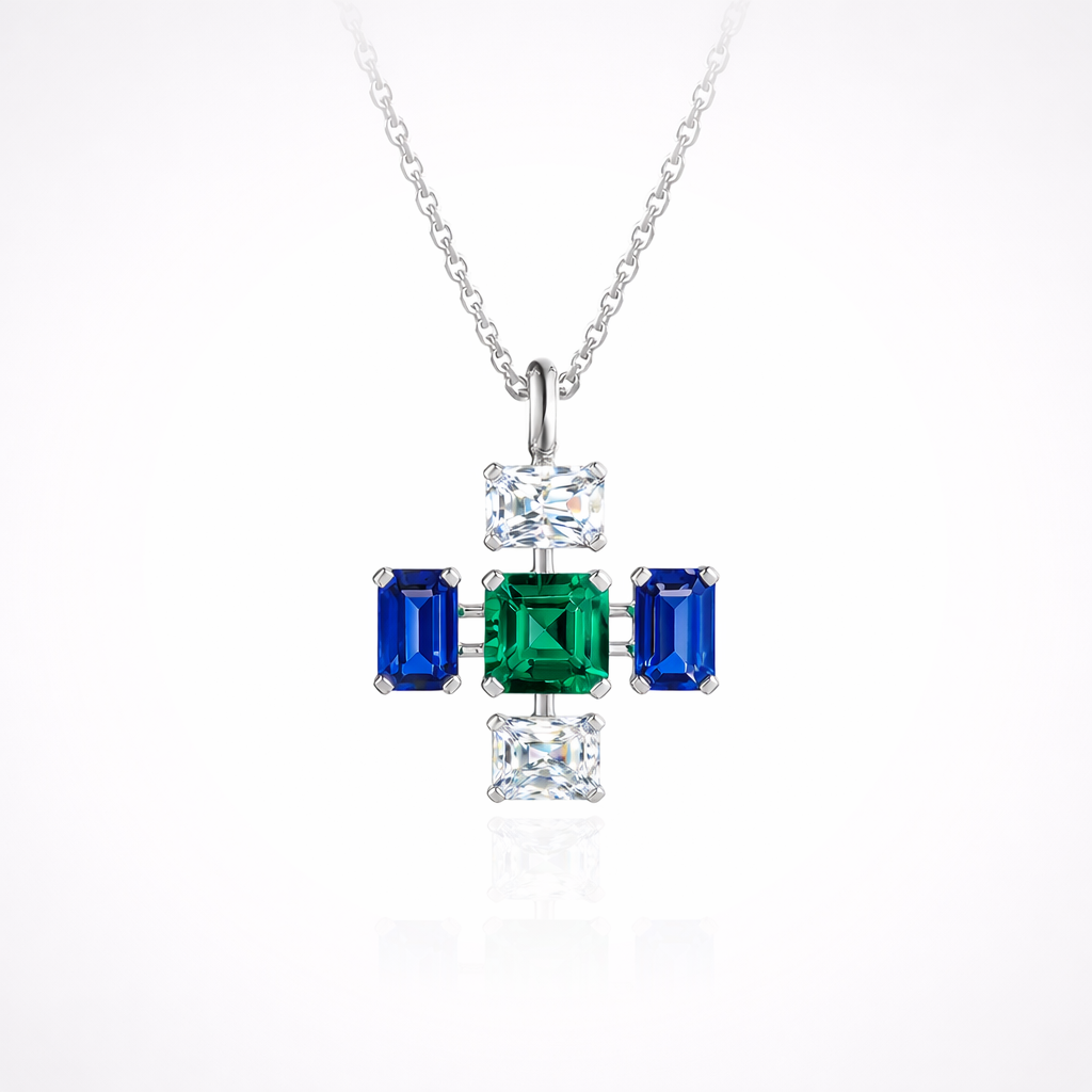 Cross pendant necklace featuring lab-grown diamond, emerald, and sapphire set in 14K white gold, shown on fine chain against white background.