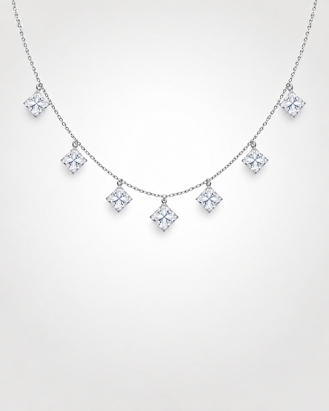 Seven princess-cut floating lab-grown diamonds suspended from a fine white gold chain with drilled corner connections and no visible prongs 