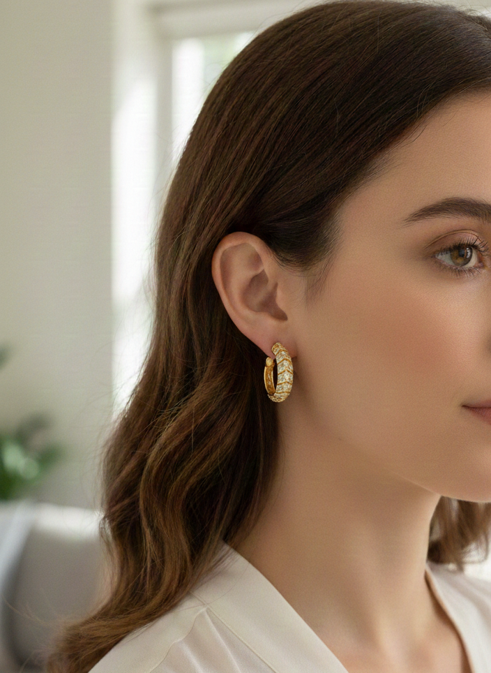 Model wearing 14K yellow gold diamond hoop earrings with baguette and round diamonds, half-set design, close-up ear view