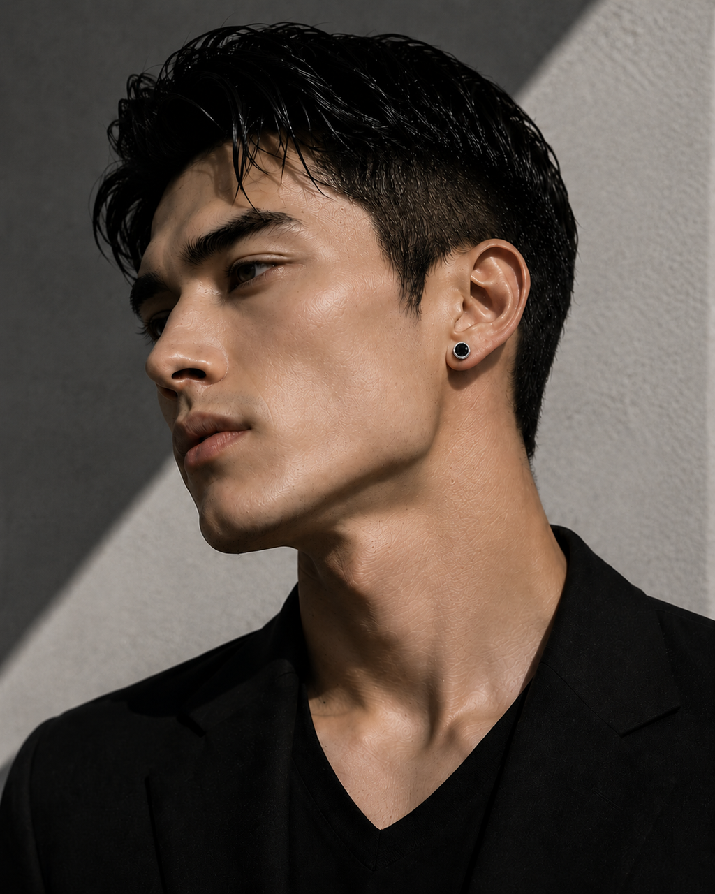 Single black diamond stud earring worn on a male model